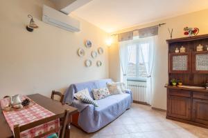 a living room with a blue couch and a table at Casa Vacanze Caterina in Corniglia
