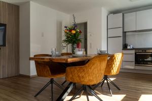 a dining room table with chairs and a vase of flowers at Hideaway Lounge Sure in Echternacherbrück