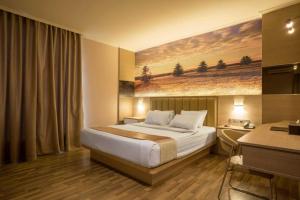 a hotel room with a bed and a desk at Star Hotel in Pontianak +156 photos