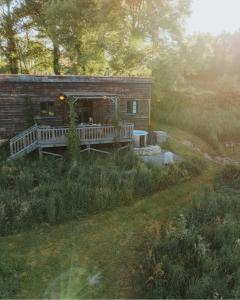 a log cabin with a porch and a deck at La ferme du pont de Maumy, cabane au bord de l'étang et bain nordique in Busserolles +59 photos