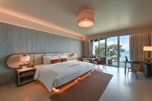 a bedroom with a large bed and a table and chairs at Rocky's Boutique Resort - Veranda Collection Samui in Lamai