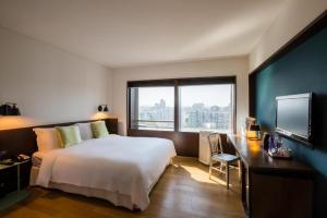 a bedroom with a bed and a desk and a television at Beijing New World Center Tongpai Hotel in Beijing