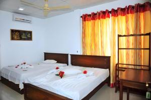 a bedroom with two beds with flowers on them at Hotel Glee in Challi +110 photos