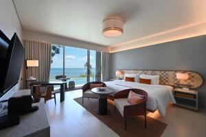 ein Schlafzimmer mit großem Bett und ein Wohnzimmer in der Unterkunft Rocky's Boutique Resort - Veranda Collection Samui in Lamai