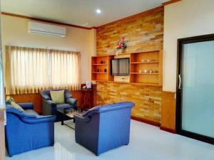 a living room with two blue chairs and a tv at CK Hills Hotel in Mae Sot