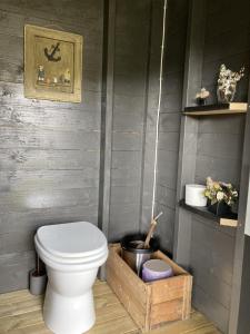 a bathroom with a toilet and a wooden box at Kleppa Gard & Glamping in Hjelmeland