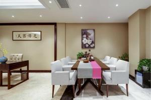 Un comedor con una mesa y sillas blancas. en ibis Styles Nanjing Qilin Gate Hotel, en Qilinmen