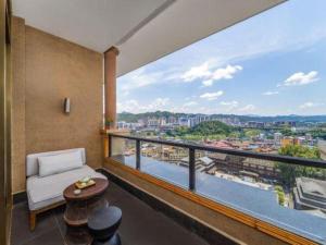 a room with a balcony with a view of a city at Jolie Vue Boutique Hotel Sanjiang in Sanjiang