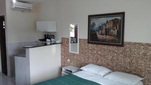 a room with a bed and a painting on the wall at Swiss Flats in Porto De Galinhas +63 photos