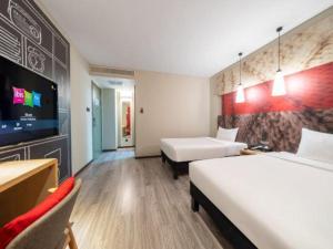a hotel room with two beds and a flat screen tv at Ibis Xian Hi-Tech Zone No.7 Keji Rd Hotel in Xi'an