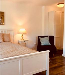 a bedroom with a bed and a chair and a lamp at Charmante Ferienwohnung 1 im Schmöllerhäuschen in Stadt Wehlen +9 photos