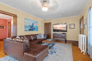 a living room with a leather couch and a flat screen tv at Uptown Urban Living in Minneapolis +10 photos