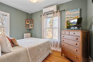 a bedroom with a bed and a dresser and a window at Uptown Urban Living in Minneapolis