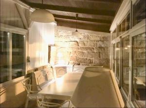 a table and chairs in a room with a stone wall at Charmante Ferienwohnung 1 im Schmöllerhäuschen in Stadt Wehlen +9 photos