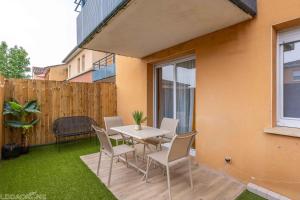 a patio with a table and chairs and a fence at COSY CAUSSADE Parking gratuit Jardinet Refait à neuf in Caussade