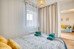 a bedroom with a bed with blue towels on it at COSY CAUSSADE Parking gratuit Jardinet Refait à neuf in Caussade