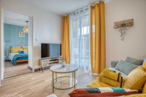 a living room with a couch and a tv at COSY CAUSSADE Parking gratuit Jardinet Refait à neuf in Caussade