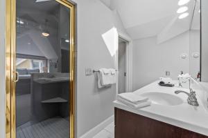 Un baño blanco con lavabo y ducha. en Harriet House, en Minneapolis 59 fotos más
