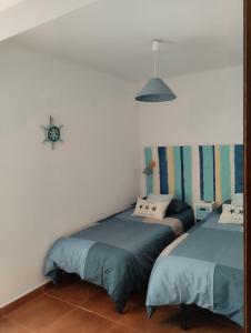 a bedroom with two beds and a mirror at Frente al mar, Doña Carmen Playa, Mejor vista de Suances in Suances