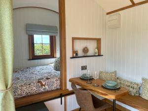 a dining room with a table and a mirror at Aberdaron Shepherd Huts in Aberdaron