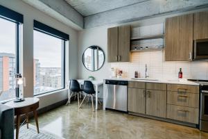 a kitchen with wooden cabinets and a large window at Sable 704 - One Bedroom in Minneapolis