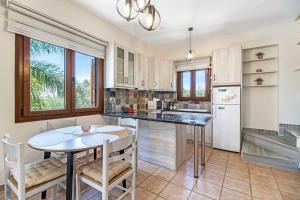 a kitchen with a table and a table and chairs at Villa Petra in Methoni