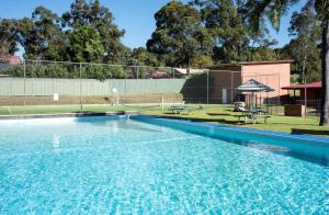 a large swimming pool with blue water in a yard at Nightcap at Archer Hotel in Nowra