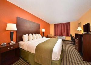 a hotel room with a large bed and a desk at Quality Inn & Suites Grinnell near University in Grinnell