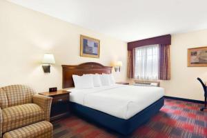 a hotel room with a bed and a chair at Best Western Stateline Lodge in West Siloam Springs