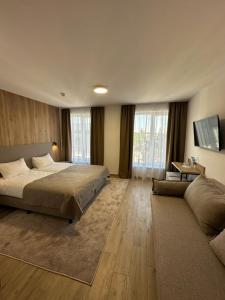 a large bedroom with a bed and a couch at Inn West Hotel by Pysanka in Kolomiya +50 photos