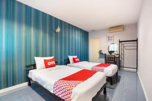 two beds in a room with blue and green walls at OYO 703 Koh Chang Riverside Resort in Ko Chang