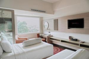 une chambre d'hôtel avec un lit et une télévision dans l'établissement Indoluxe Hotel Jogjakarta, à Kejayan