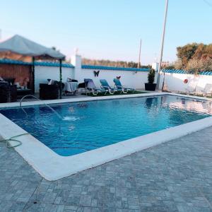 a swimming pool with two chairs at Villa lujo Elche in Asprillas