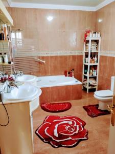 a bathroom with two sinks and a tub and a toilet at Villa lujo Elche in Asprillas