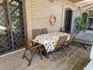 a table and chairs sitting on a patio at Villa Colle degli Ulivi con piscina e sguardo sul mare in Cerveteri