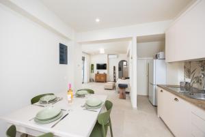 a kitchen and living room with a white table and chairs at Villa Erofili in Agia Triada