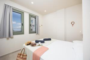 a white bedroom with a bed and a window at Villa Erofili in Agia Triada +26 photos