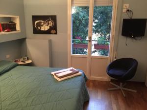 une chambre avec un lit, une chaise et une fenêtre dans l'établissement Casa Albert, à Bologne