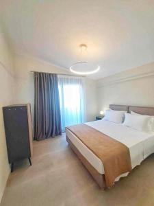 a bedroom with a large bed and a window at Horizon Suite in Nikiti