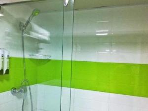 ein Bad mit einer Dusche mit grünen und weißen Wänden in der Unterkunft 7 Days Inn Tianjin Zhongshan Road North Station in Tianjin