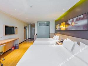 a hotel room with two beds and a flat screen tv at IU Hotel Tianjin Tianta Scenic Spot Wujiayao Metro Station in Tianjin