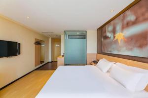 a bedroom with a large bed and a flat screen tv at IU Hotel Tianjin Tianta Scenic Spot Wujiayao Metro Station in Tianjin +188 photos