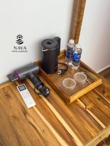 a table with a phone and water bottles on it at Nava Hotel & Resort in Dong Hoi
