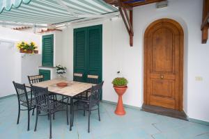 jadalnia ze stołem i krzesłami oraz drewnianymi drzwiami w obiekcie Appartamento Iasolino w mieście Ischia