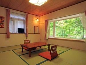 a living room with a table and chairs and a window at Yumekiko in Nasushiobara