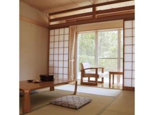 a living room with a table and a window at Kyoto Keburikawa Hotel in Kameoka