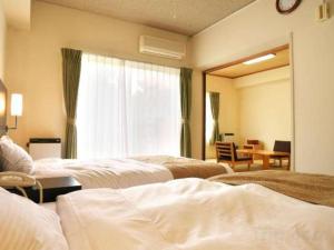 a hotel room with two beds and a mirror at WISTERIAN LIFE CLUB Nojiriko in Yamanouchi