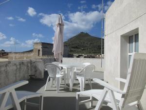 patio con tavolo, sedie e ombrellone di Favignana Vacanze a Favignana