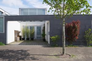 a house with a white door and a tree at Villa Yburg in Amsterdam