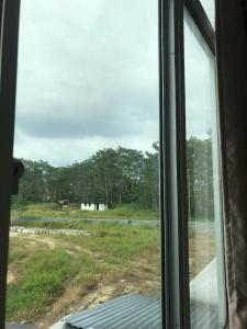 a window with a view of a field with trees at VIVA HOTEL SRI AMAN in Simanggang +56 photos